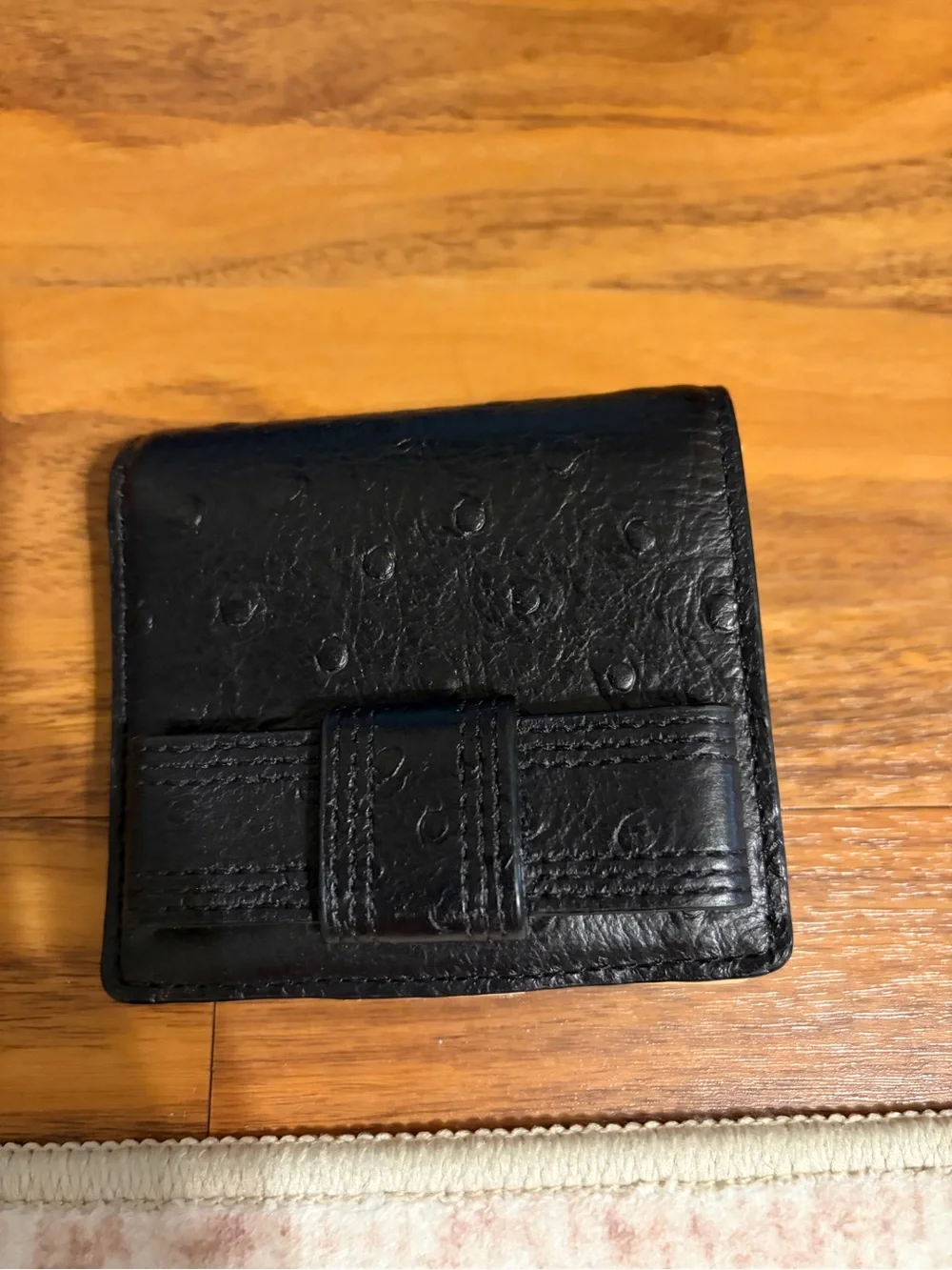 Kate Spade black ostrich embossed textured leather wallet.