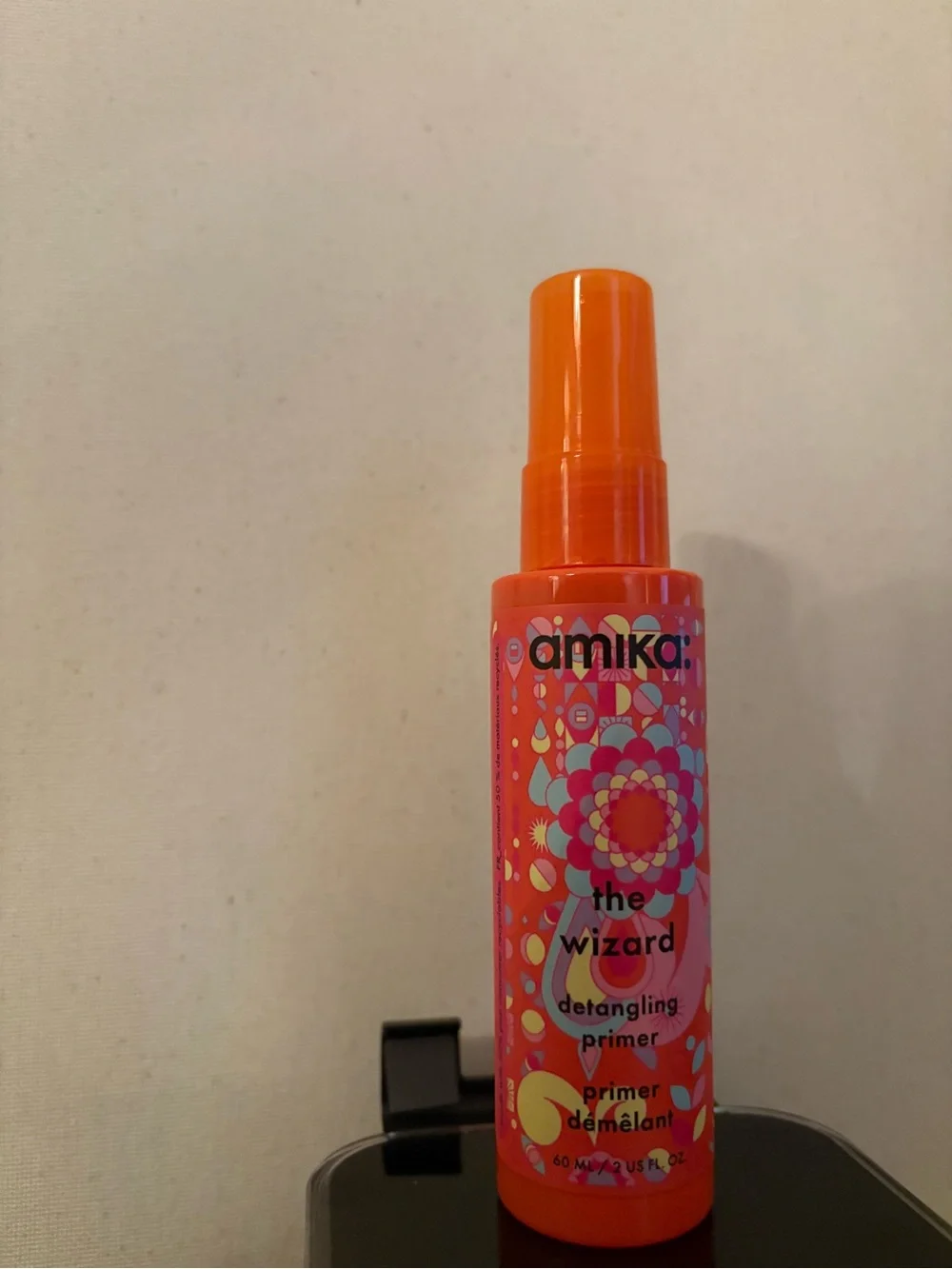 amika Bright Orange Detangling Primer with Pink and Yellow Floral Label